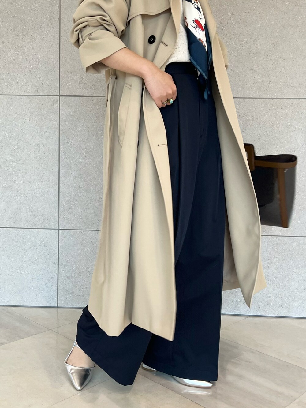 ベージュ系のトレンチコート、ホワイト系のニット/セーター、ブルー系のハンドバッグを着用したレディースの春コーディネートの5枚目の写真