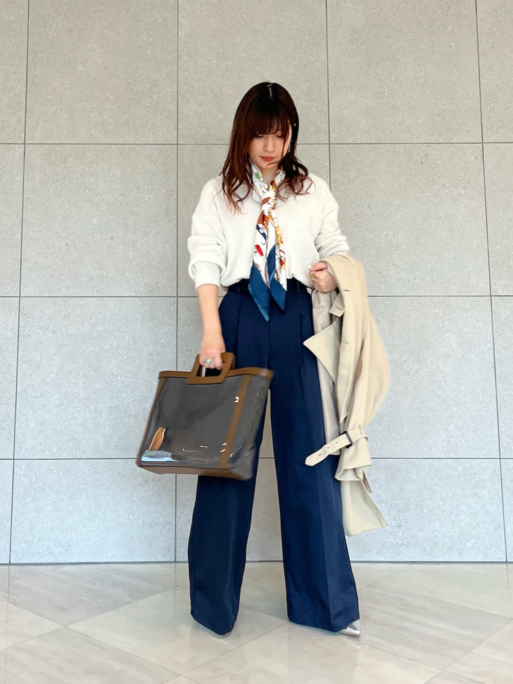 ベージュ系のトレンチコート、ホワイト系のニット/セーター、ブルー系のハンドバッグを着用したレディースの春コーディネートの3枚目の写真