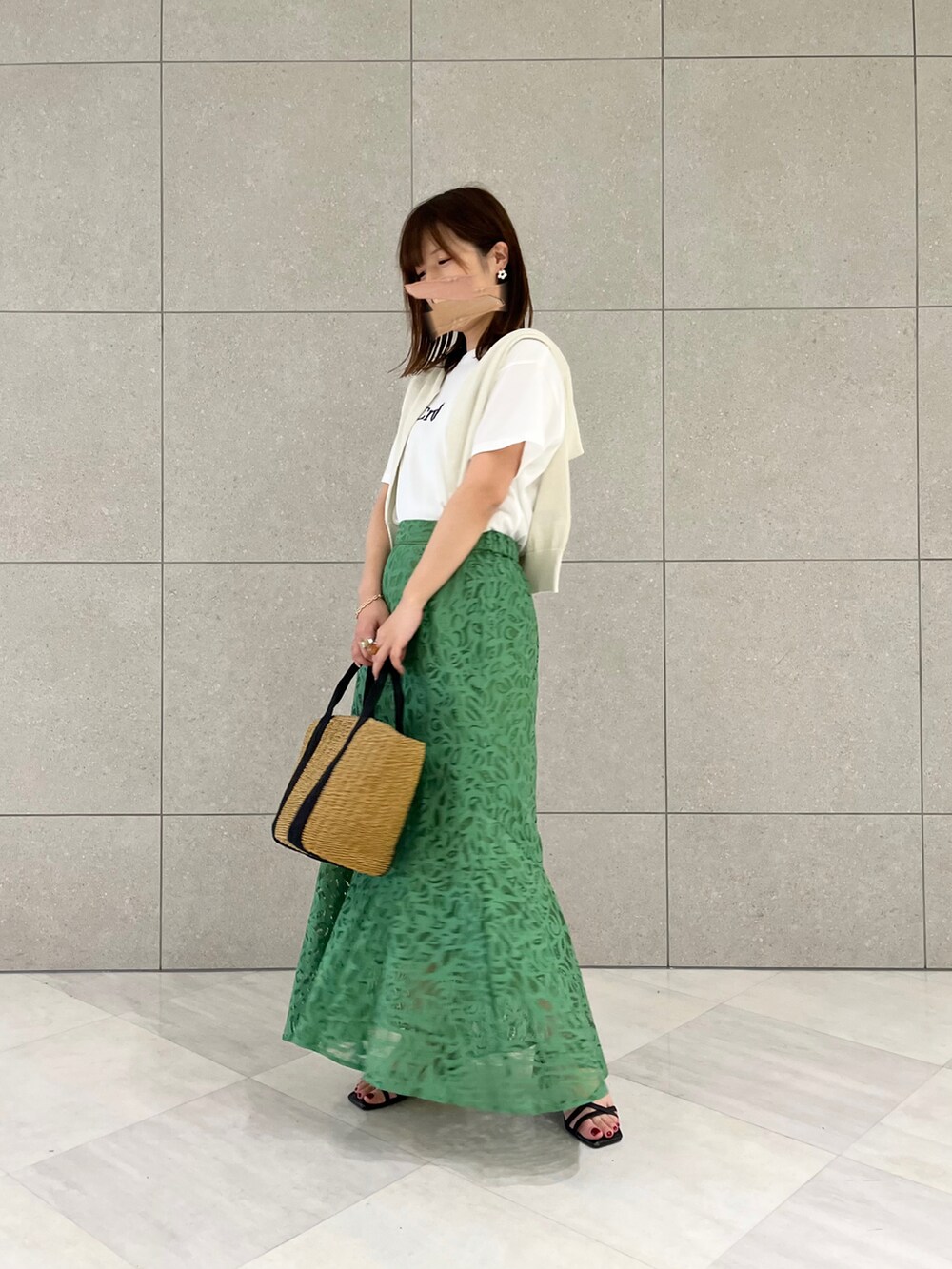 ホワイト系のTシャツ/カットソー、ゴールド系のカーディガン/ボレロ、イエロー系のハンドバッグを着用したレディースの春コーディネートの2枚目の写真
