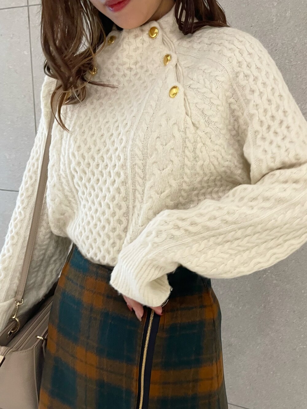 ブラウン系のブーツ、ホワイト系のニット/セーター、オレンジ系のスカートを着用したレディースの秋コーディネートの3枚目の写真