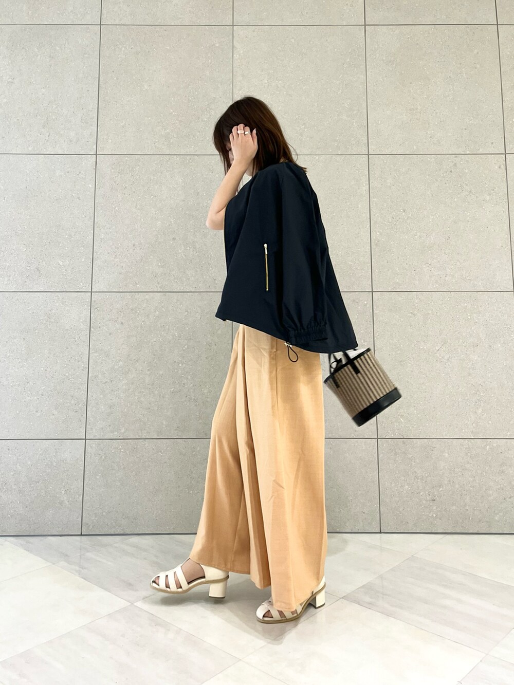 ホワイト系のTシャツ/カットソー、ブラック系のブルゾン、オレンジ系のその他パンツを着用したレディースの春コーディネートの2枚目の写真