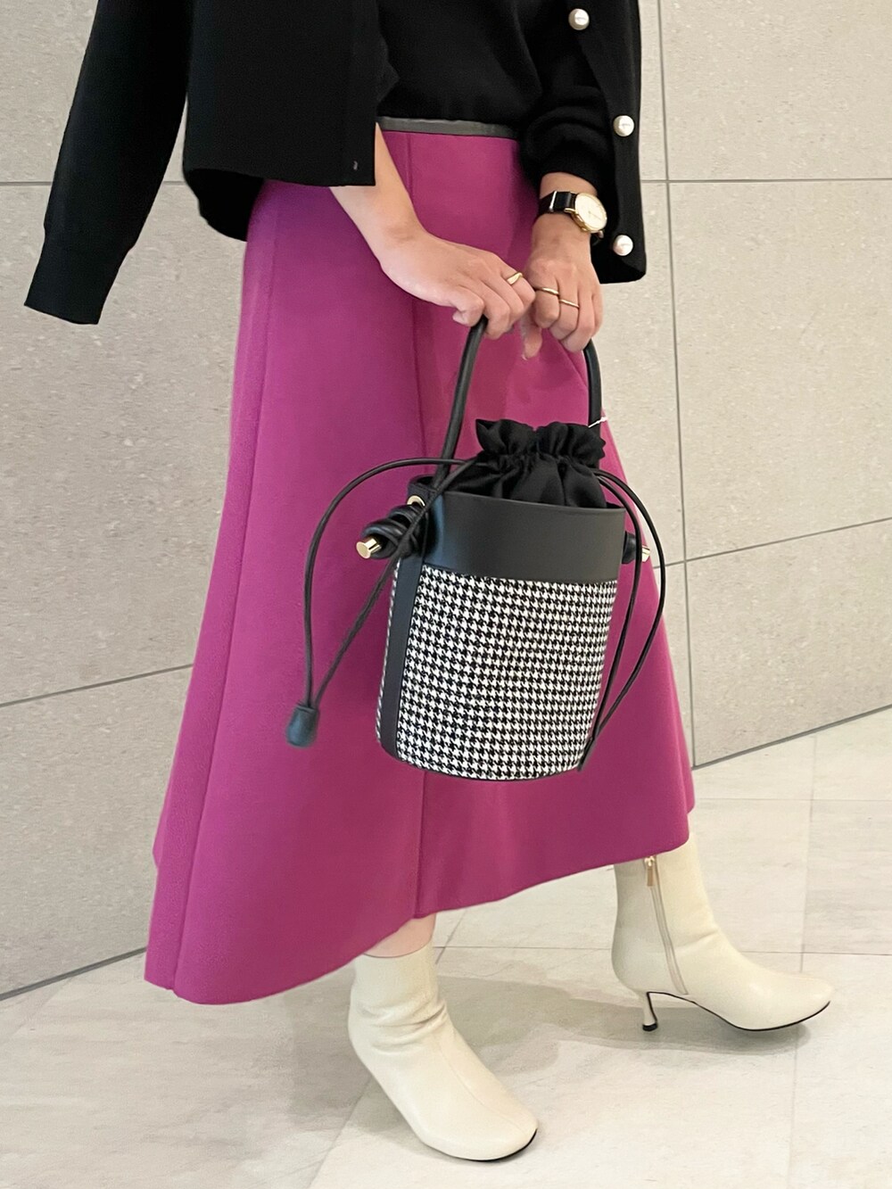 ブラック系のニット/セーター、ブラック系のカーディガン/ボレロ、ピンク系のスカートを着用したレディースの秋コーディネートの4枚目の写真