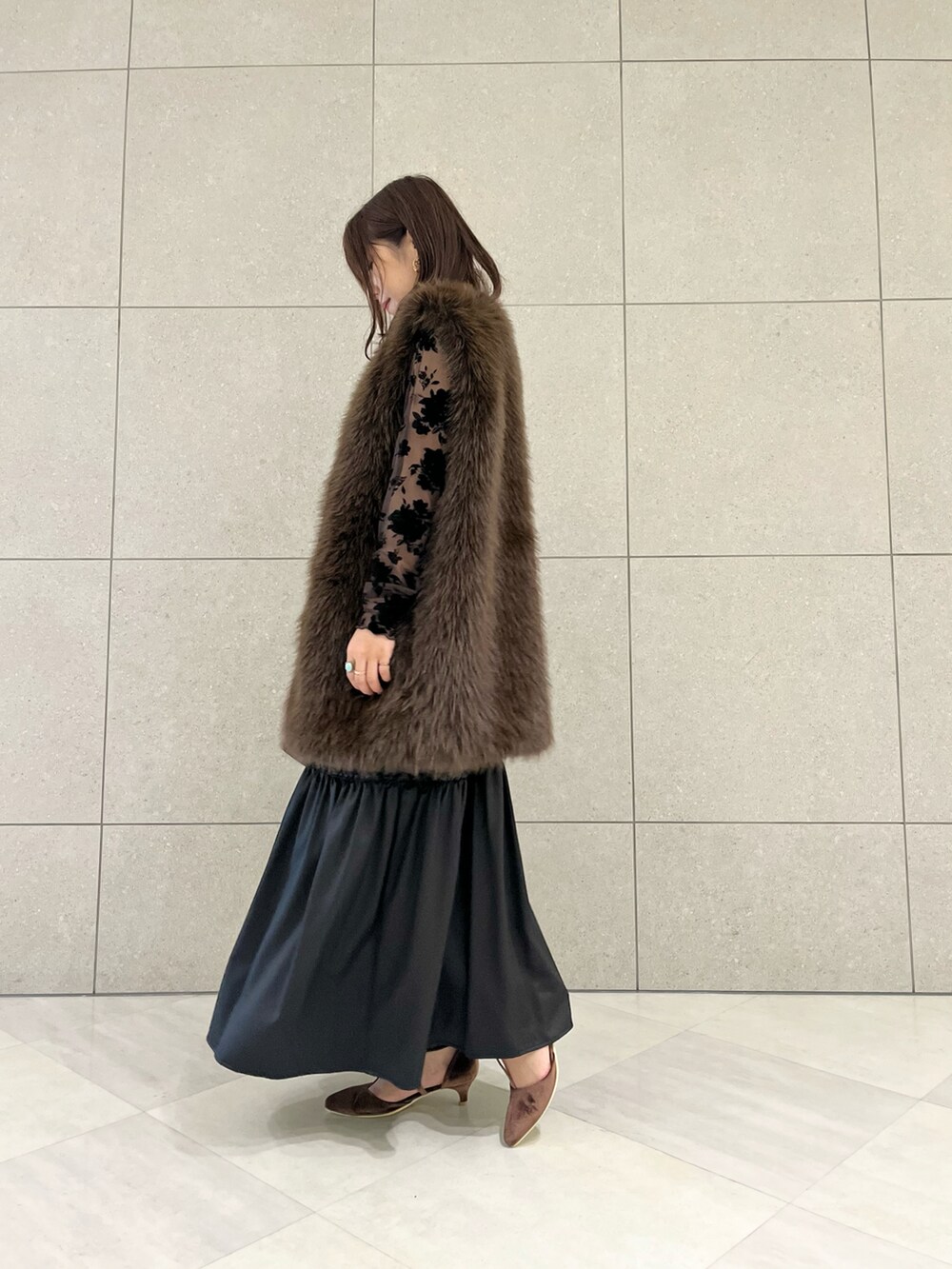 ブラウン系のベスト、ブラウン系のTシャツ/カットソー、ブラック系のワンピースを着用したレディースの秋コーディネートの2枚目の写真