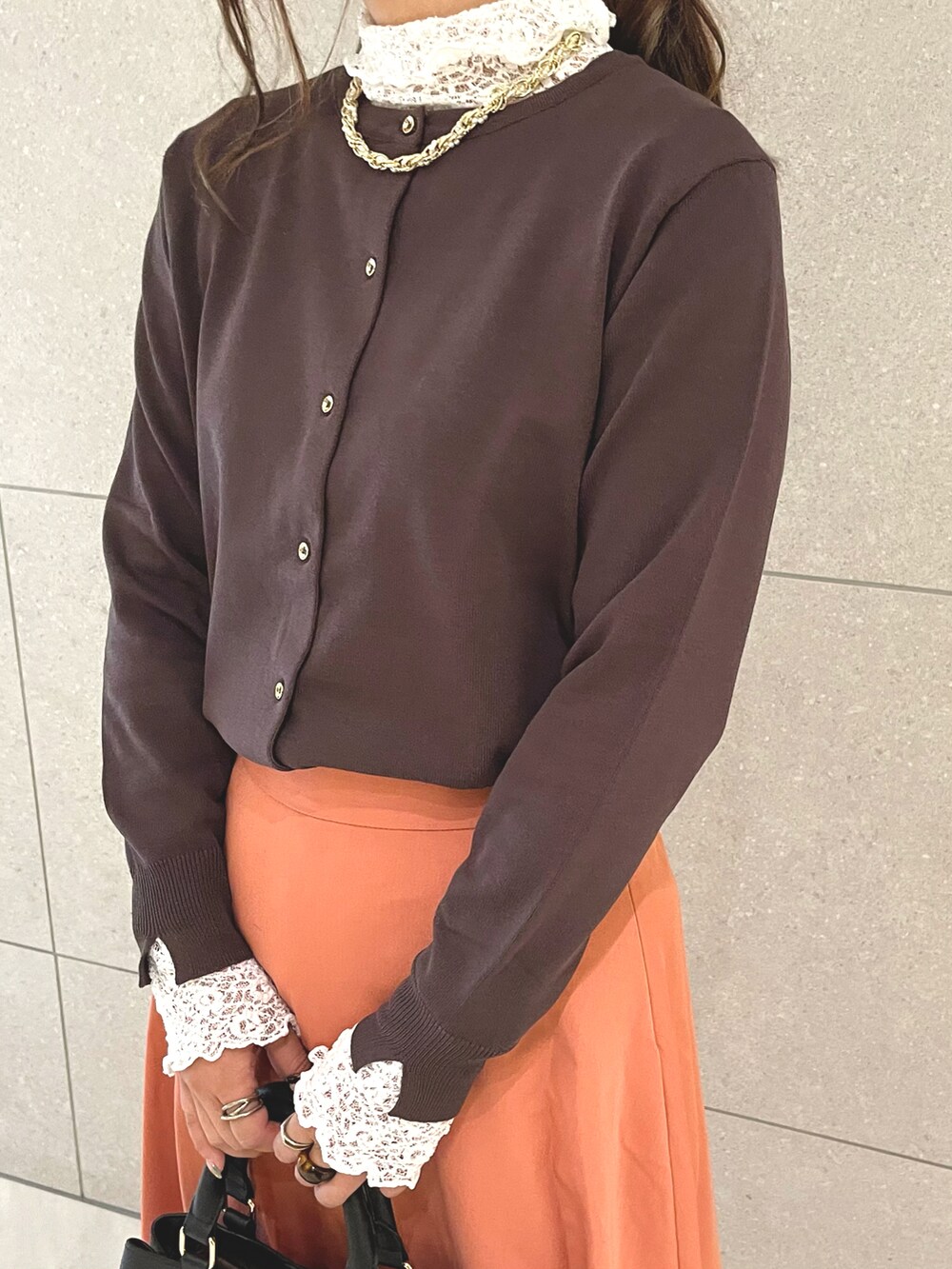 ブラウン系のカーディガン/ボレロ、ホワイト系のTシャツ/カットソー、ブラウン系のハンドバッグを着用したレディースの秋コーディネートの3枚目の写真