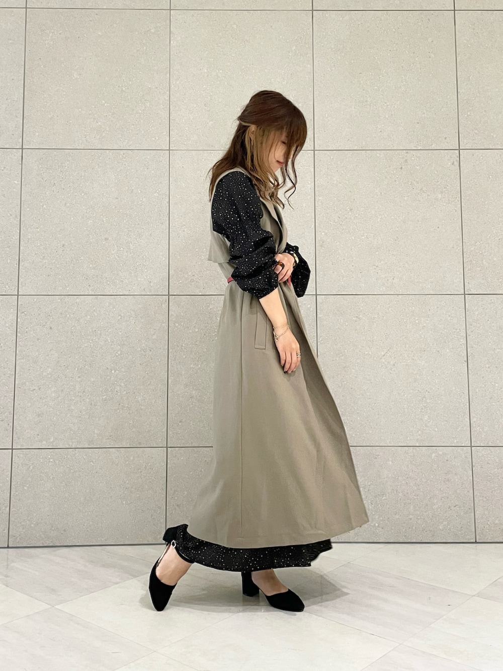 ブラウン系のトレンチコート、ブラック系のワンピース、ブラック系のパンプスを着用したレディースの秋コーディネートの2枚目の写真