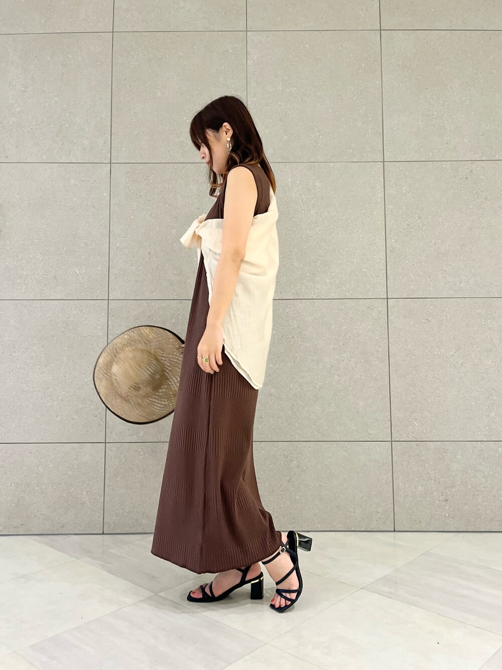 ブラウン系のワンピース、ホワイト系のシャツ/ブラウス、ブラック系のサンダルを着用したレディースの夏コーディネートの2枚目の写真