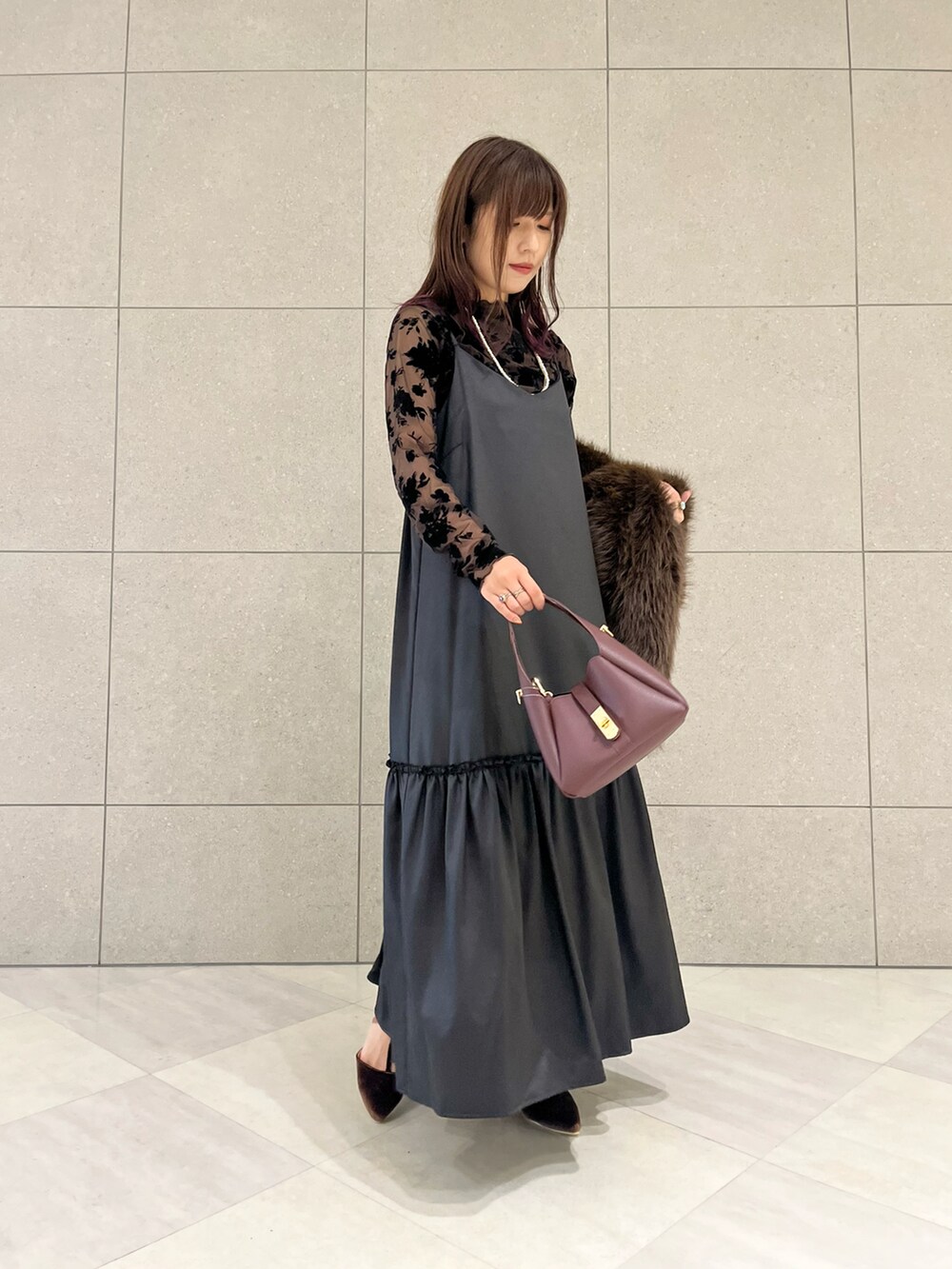 ブラウン系のベスト、ブラウン系のTシャツ/カットソー、ブラック系のワンピースを着用したレディースの秋コーディネートの3枚目の写真