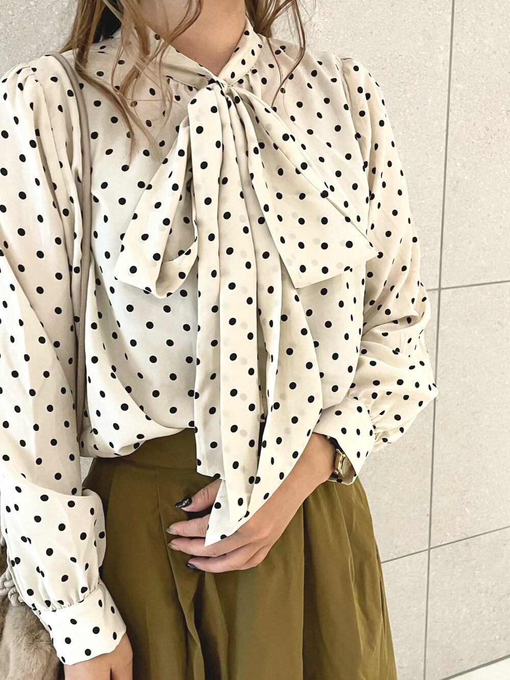 ホワイト系のシャツ/ブラウス、ブラウン系のスカート、ベージュ系のハンドバッグを着用したレディースの秋コーディネートの3枚目の写真