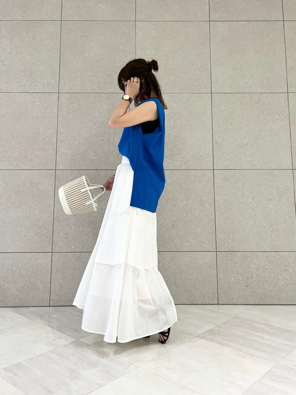 ブルー系のTシャツ/カットソー、ホワイト系のスカート、ホワイト系のハンドバッグを着用したレディースの夏コーディネートの2枚目の写真