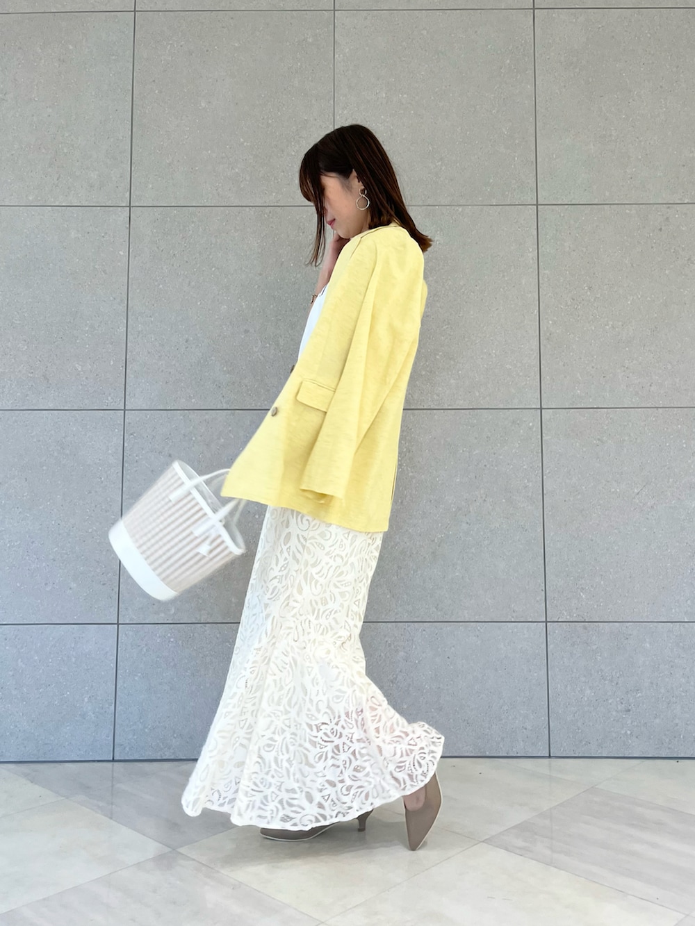 イエロー系のノーカラージャケット、ホワイト系のTシャツ/カットソー、ホワイト系のハンドバッグを着用したレディースの春コーディネートの3枚目の写真