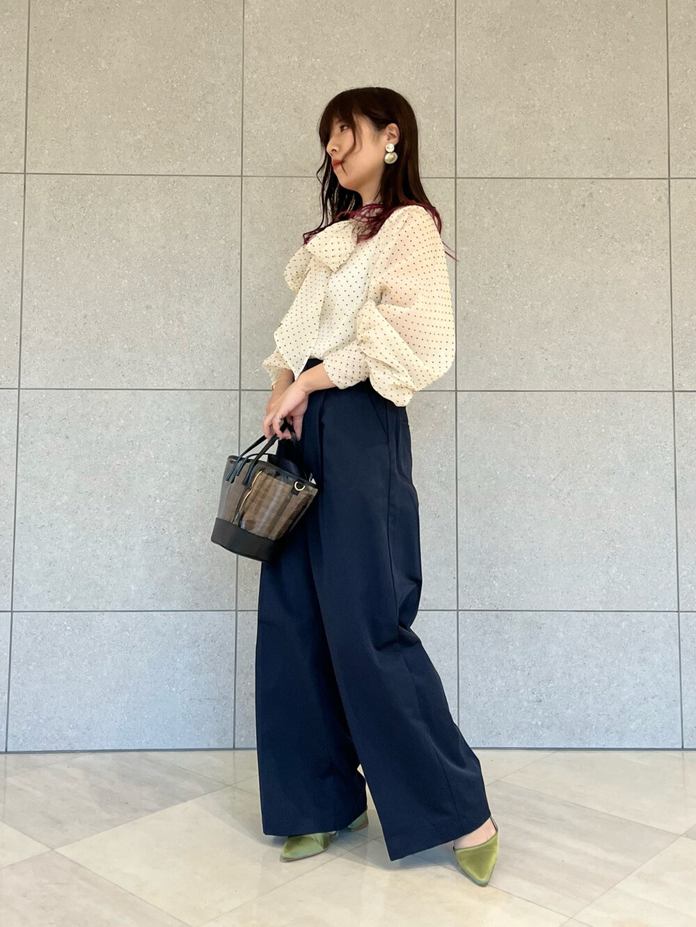 ブルー系のチノパンツ、グリーン系のパンプス、ベージュ系のシャツ/ブラウスを着用したレディースの春コーディネートの2枚目の写真