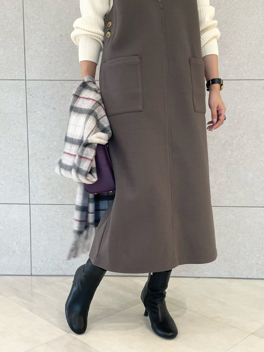 ホワイト系のニット/セーター、グレー系のジャンパースカート、パープル系のハンドバッグを着用したレディースの冬コーディネートの4枚目の写真