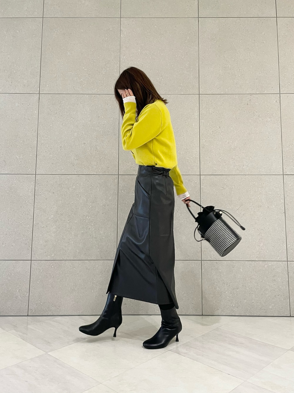 パープル系のカーディガン/ボレロ、ホワイト系のTシャツ/カットソー、ブラック系のスカートを着用したレディースの冬コーディネートの2枚目の写真