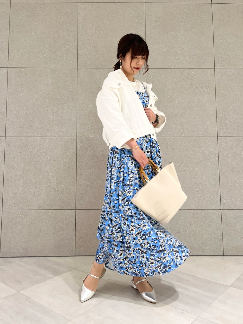 ホワイト系のノーカラージャケット、ホワイト系のニット/セーター、ブルー系のワンピースを着用したレディースの春コーディネートの2枚目の写真