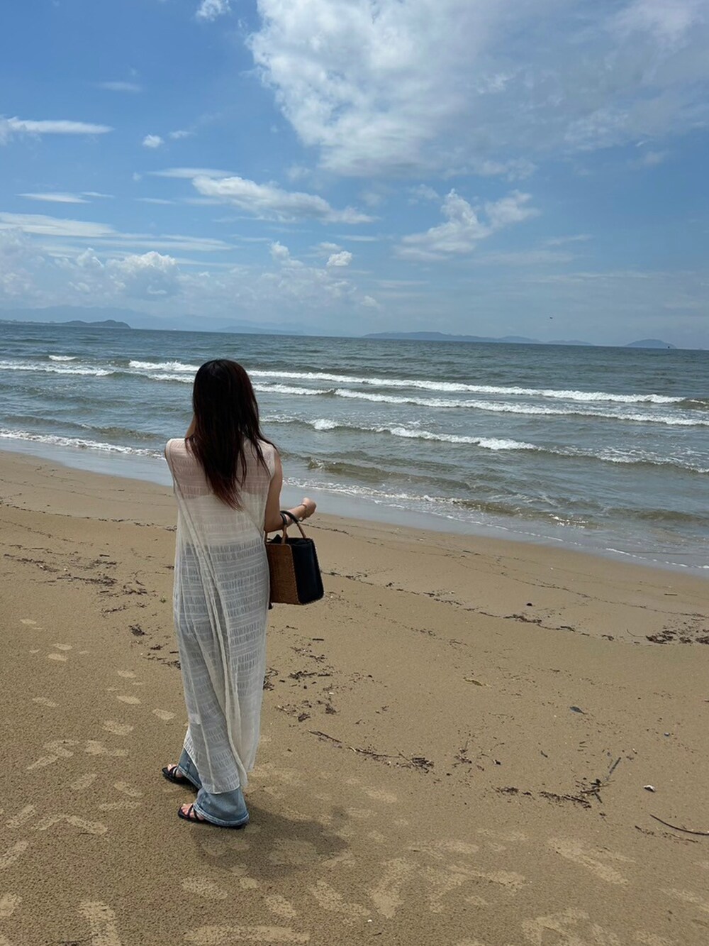 ホワイト系のワンピース、ブルー系のその他パンツ、ブラック系のサンダルを着用したレディースの夏コーディネートの2枚目の写真