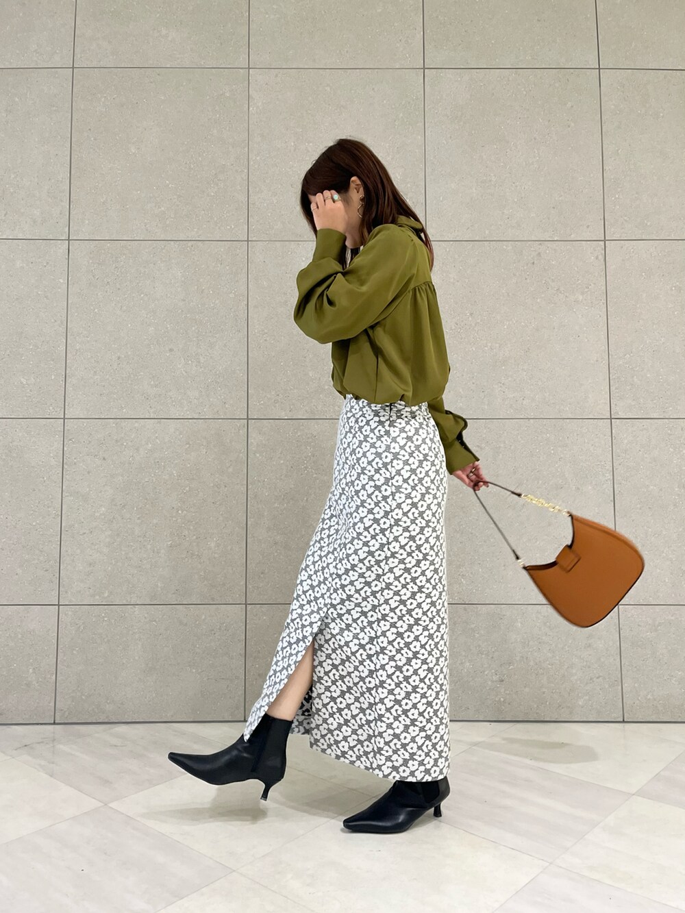 グリーン系のシャツ/ブラウス、グレー系のスカート、イエロー系のハンドバッグを着用したレディースの秋コーディネートの3枚目の写真