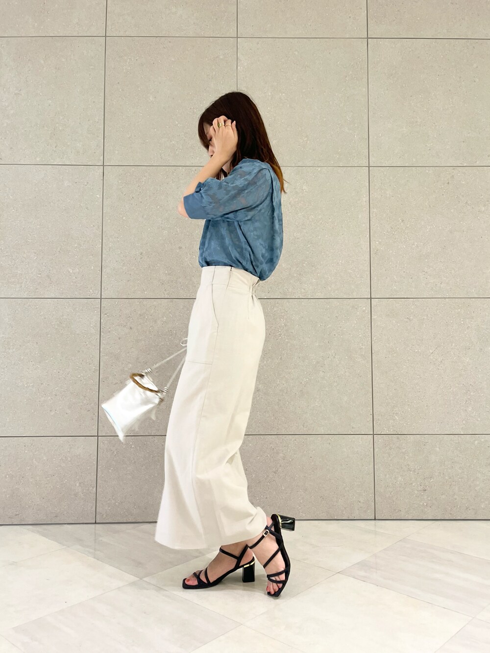 ブルー系のシャツ/ブラウス、ベージュ系のスカート、シルバー系のハンドバッグを着用したレディースの夏コーディネートの3枚目の写真