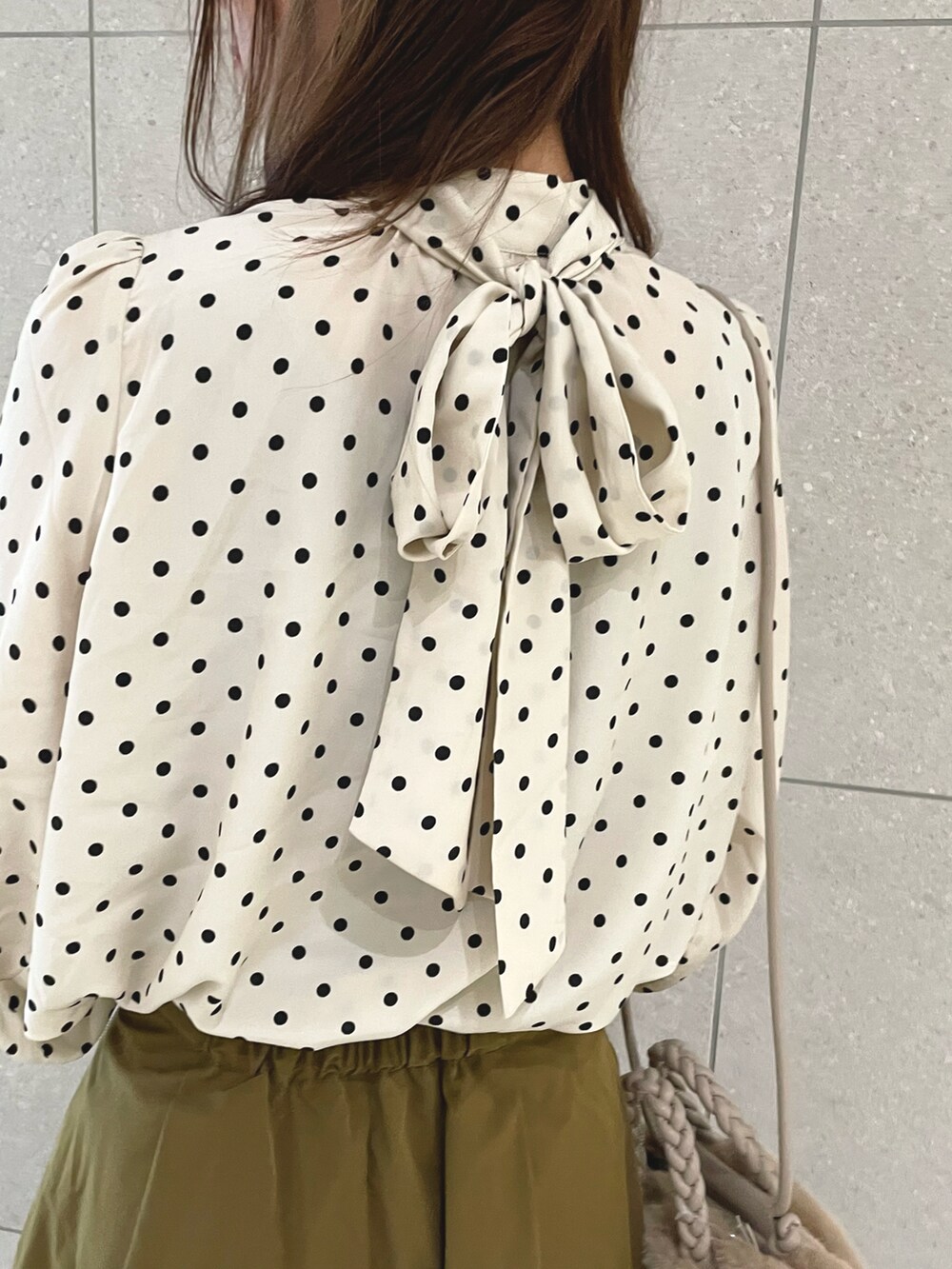 ホワイト系のシャツ/ブラウス、ブラウン系のスカート、ベージュ系のハンドバッグを着用したレディースの秋コーディネートの4枚目の写真