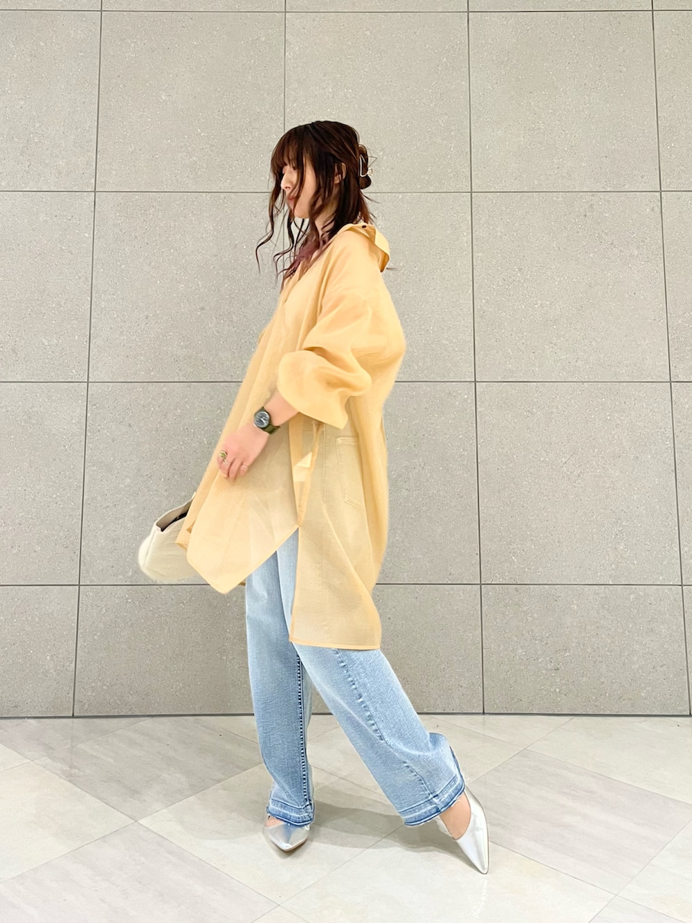 オレンジ系のワンピース、ブルー系のその他パンツ、ホワイト系のハンドバッグを着用したレディースの春コーディネートの2枚目の写真