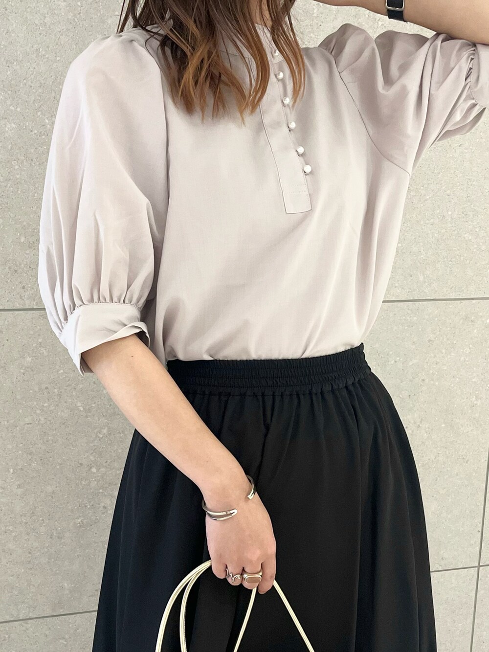 グレー系のシャツ/ブラウス、ブラウン系のスカート、ゴールド系のハンドバッグを着用したレディースの夏コーディネートの3枚目の写真