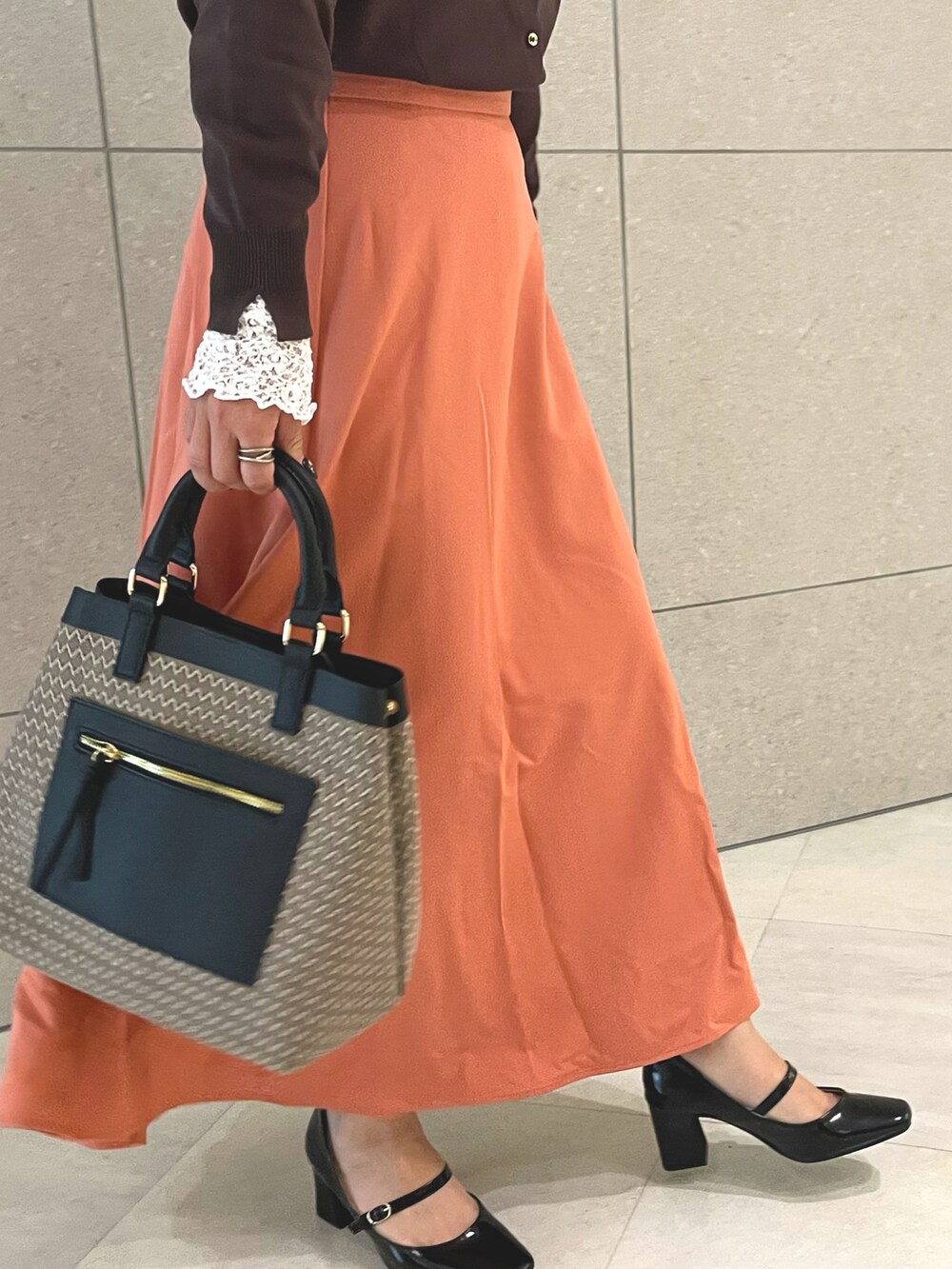 ブラウン系のカーディガン/ボレロ、ホワイト系のTシャツ/カットソー、ブラウン系のハンドバッグを着用したレディースの秋コーディネートの5枚目の写真