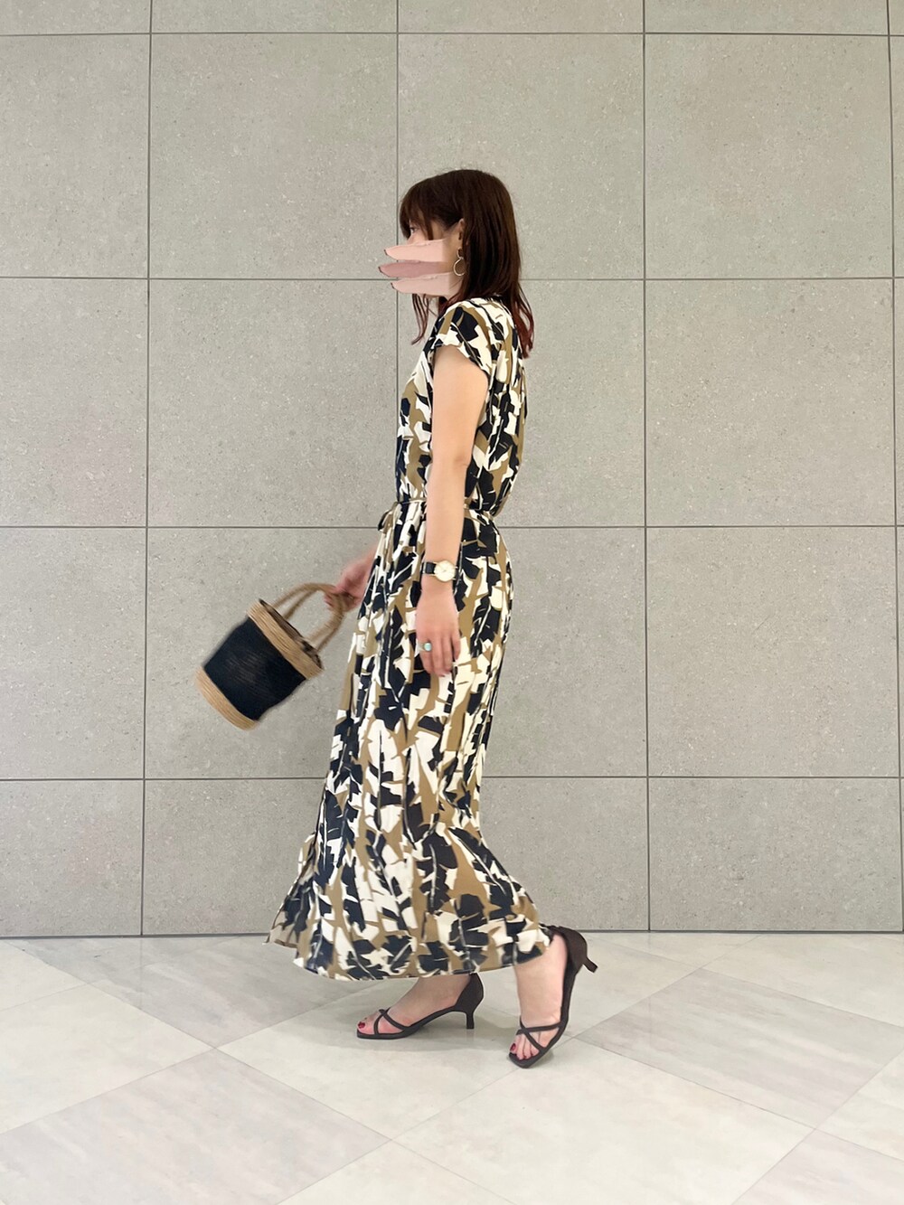 ベージュ系のワンピース、ブラック系のバッグ、ブラウン系のサンダルを着用したレディースの春コーディネートの2枚目の写真