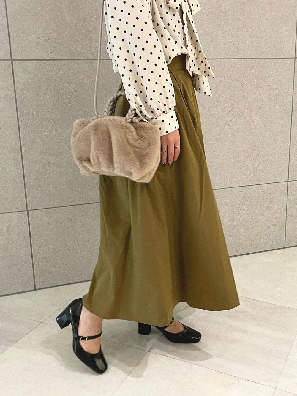 ホワイト系のシャツ/ブラウス、ブラウン系のスカート、ベージュ系のハンドバッグを着用したレディースの秋コーディネートの5枚目の写真