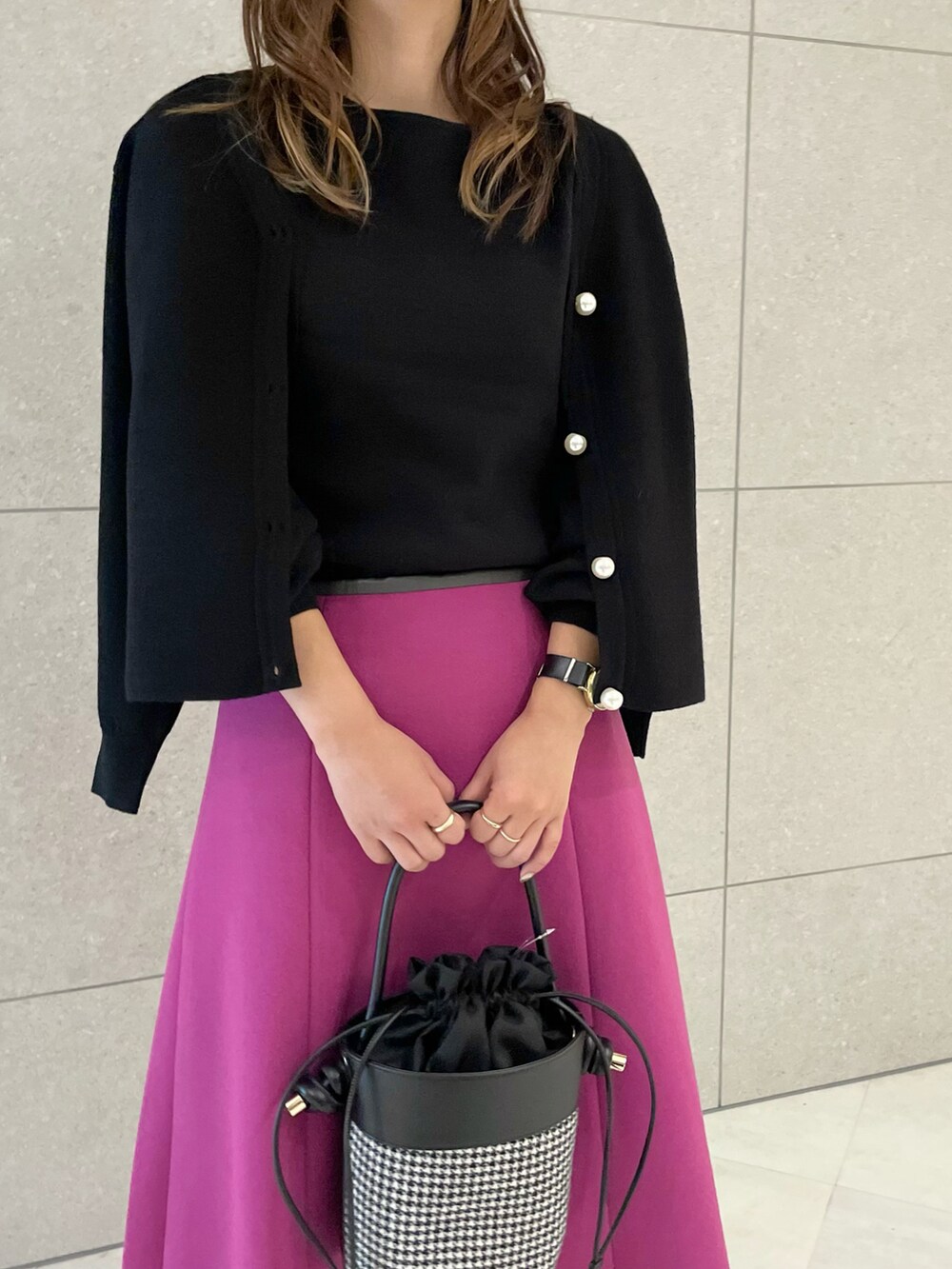ブラック系のニット/セーター、ブラック系のカーディガン/ボレロ、ピンク系のスカートを着用したレディースの秋コーディネートの3枚目の写真