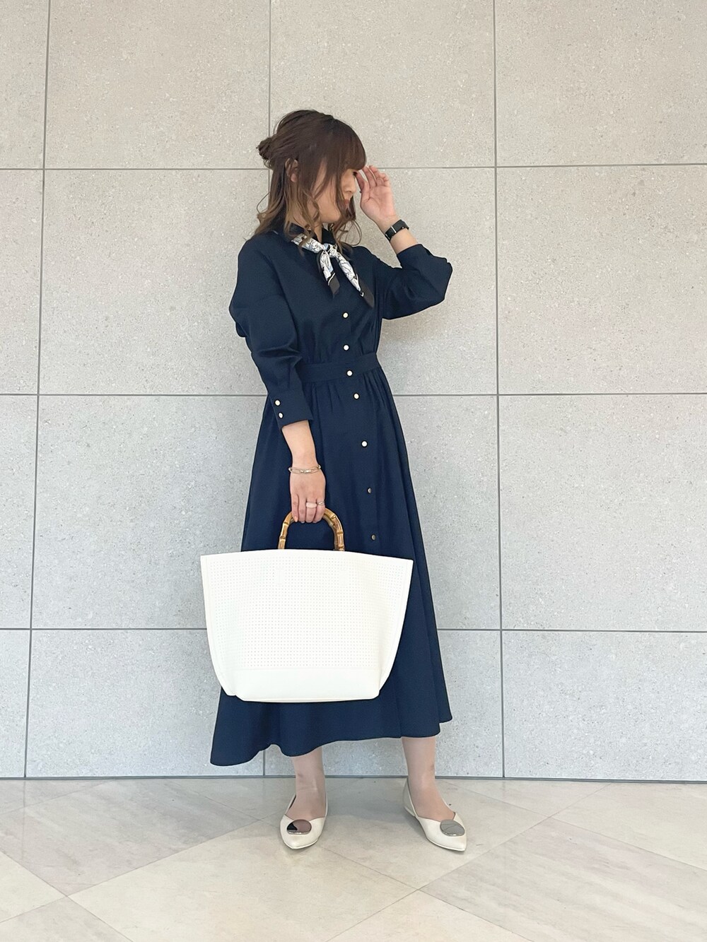 ブルー系のワンピース、ホワイト系のトートバッグ、ホワイト系のパンプスを着用したレディースの春コーディネートの2枚目の写真