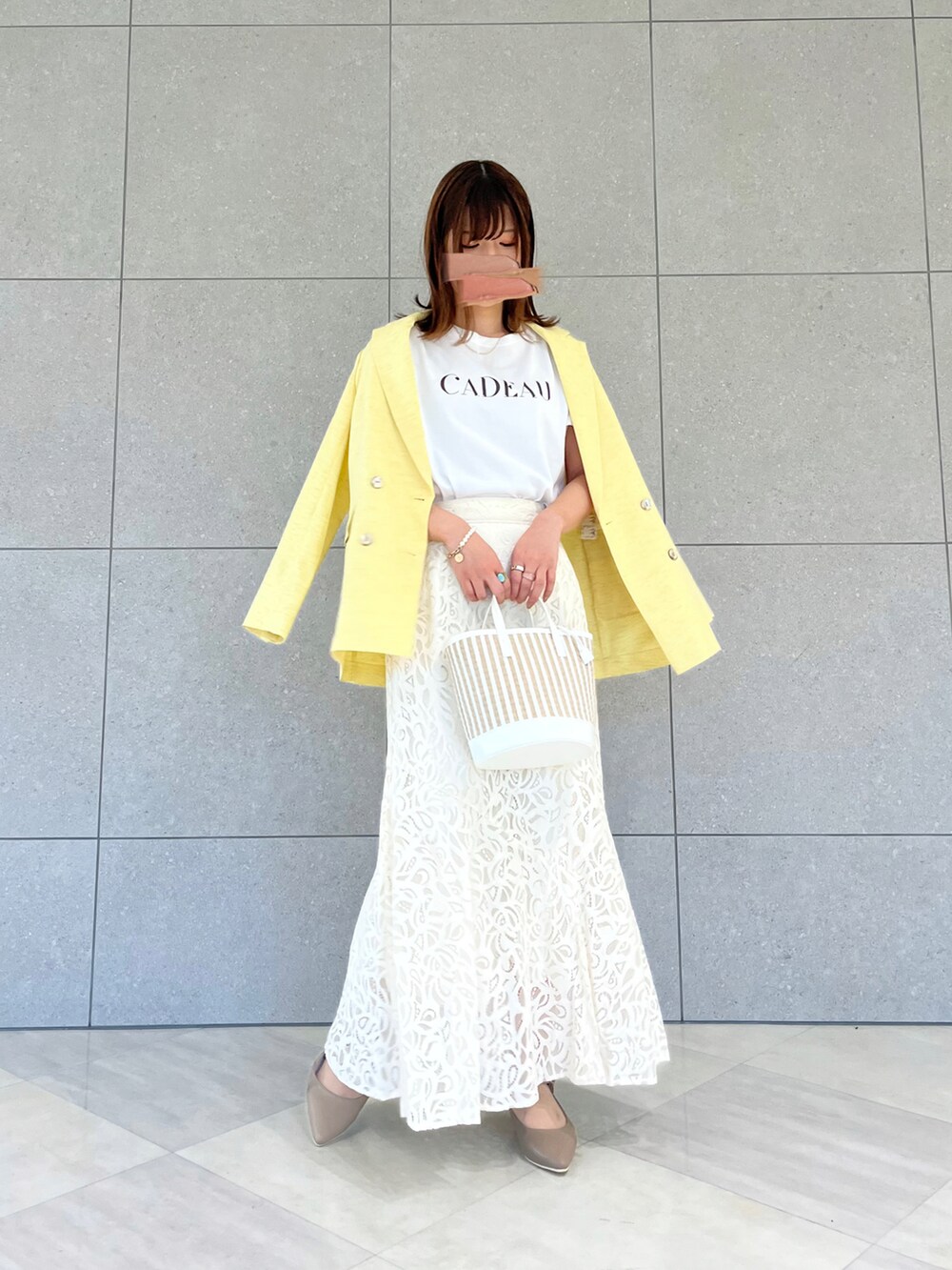 イエロー系のノーカラージャケット、ホワイト系のTシャツ/カットソー、ホワイト系のハンドバッグを着用したレディースの春コーディネートの2枚目の写真