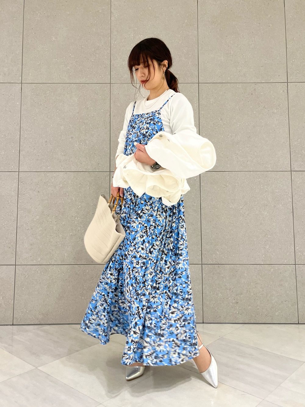 ホワイト系のノーカラージャケット、ホワイト系のニット/セーター、ブルー系のワンピースを着用したレディースの春コーディネートの3枚目の写真