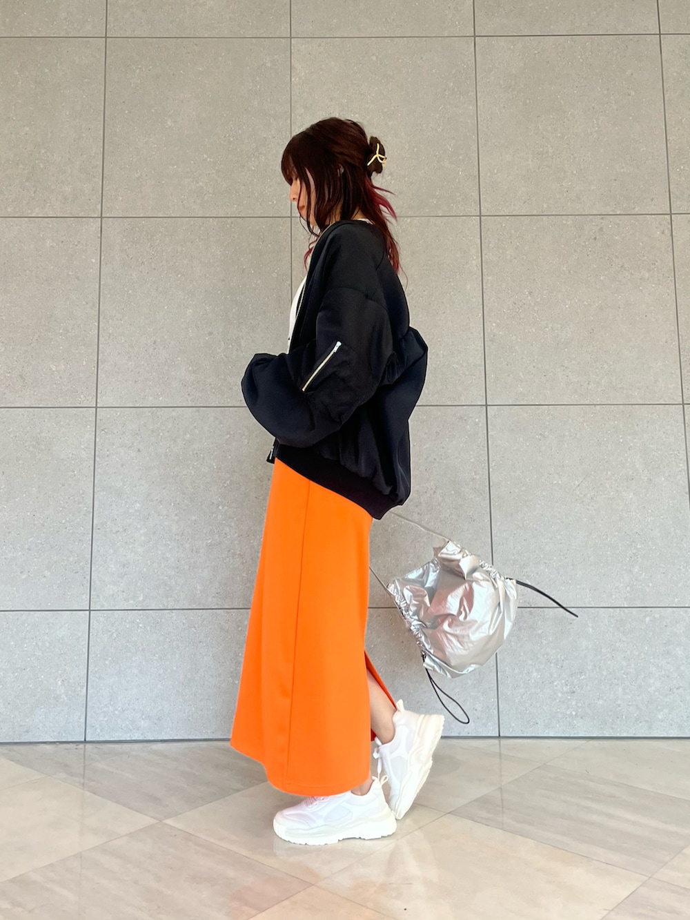 ホワイト系のTシャツ/カットソー、ブラック系のノーカラージャケット、オレンジ系のスカートを着用したレディースの春コーディネートの3枚目の写真