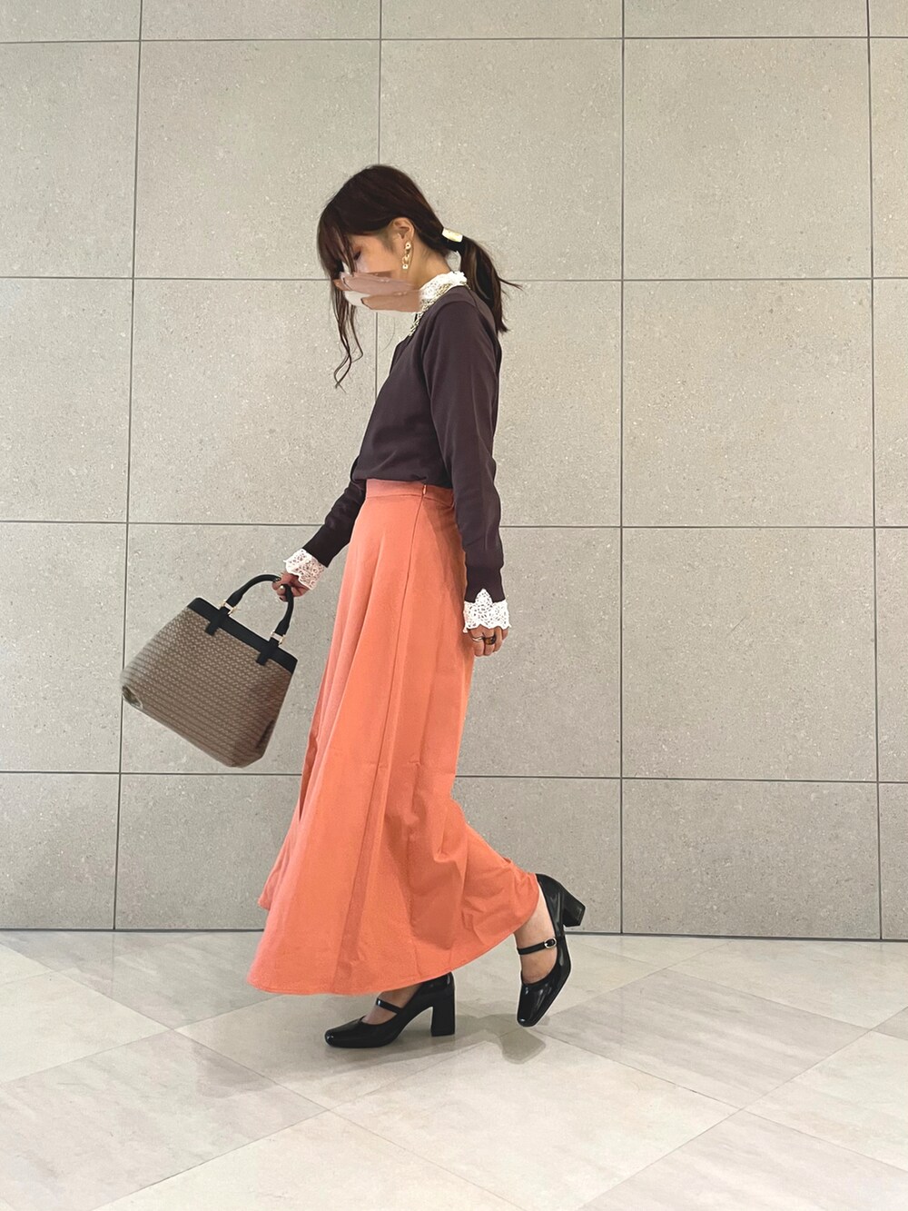 ブラウン系のカーディガン/ボレロ、ホワイト系のTシャツ/カットソー、ブラウン系のハンドバッグを着用したレディースの秋コーディネートの2枚目の写真