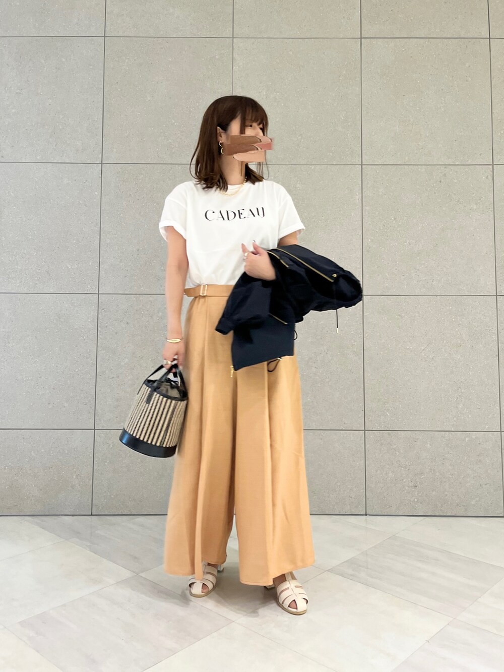 ホワイト系のTシャツ/カットソー、ブラック系のブルゾン、オレンジ系のその他パンツを着用したレディースの春コーディネートの3枚目の写真