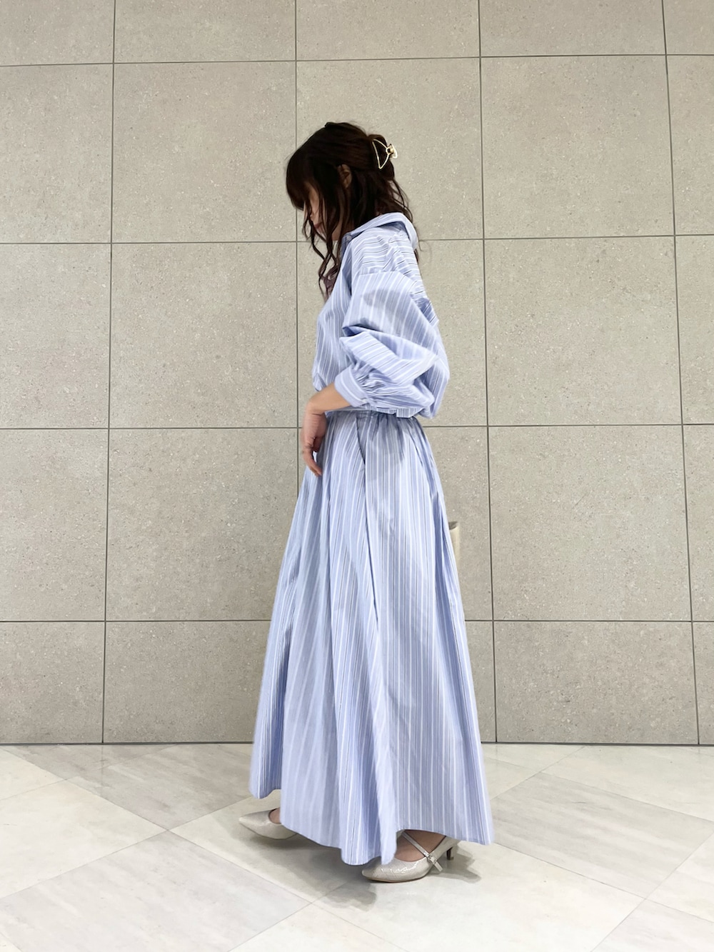 ブルー系のシャツ/ブラウス、ブルー系のスカート、ホワイト系のハンドバッグを着用したレディースの冬コーディネートの3枚目の写真