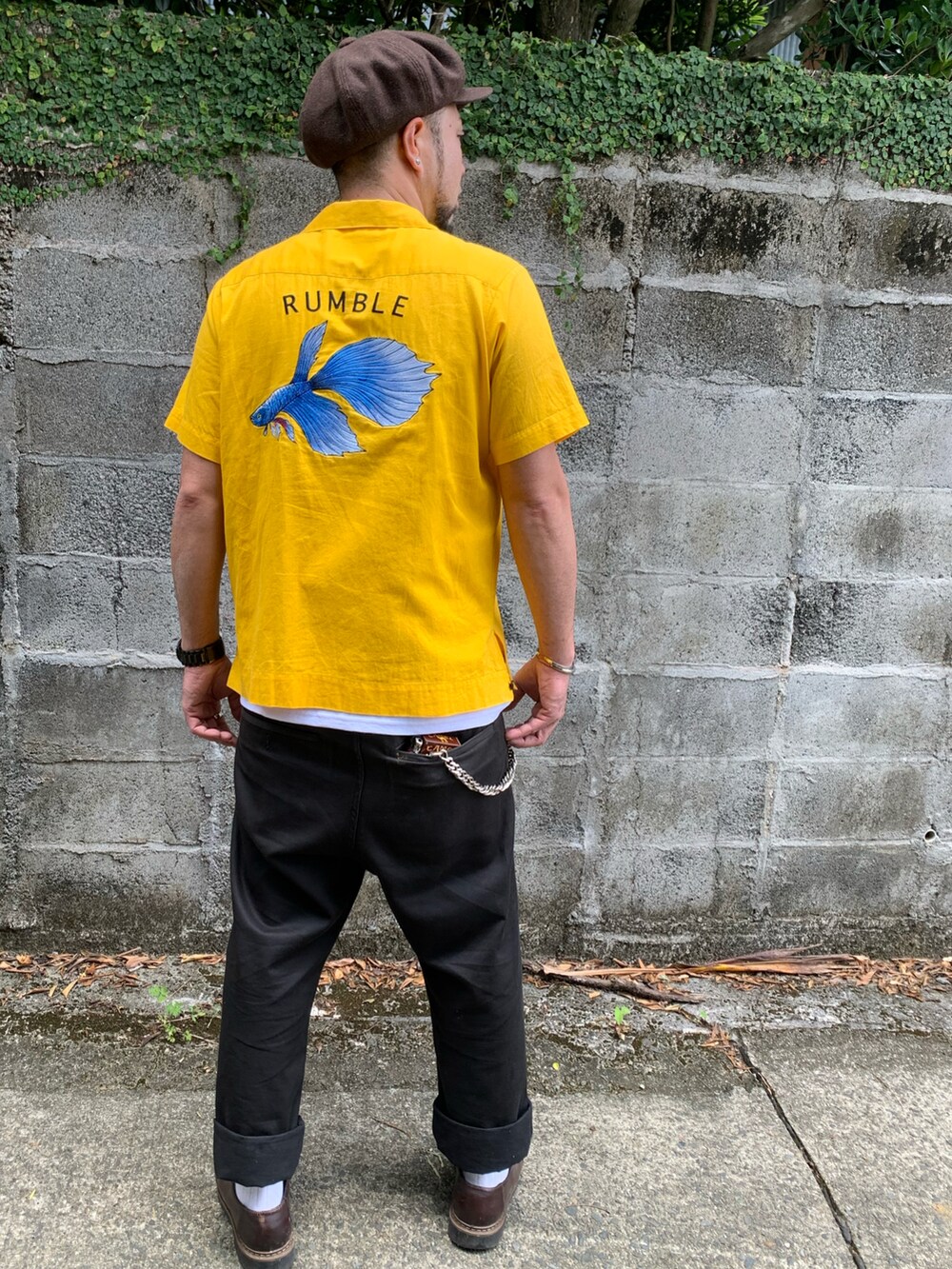 イエロー系のシャツ/ブラウス、ブラック系のチノパンツ、ブラウン系のキャスケットを着用したメンズの春コーディネートの2枚目の写真