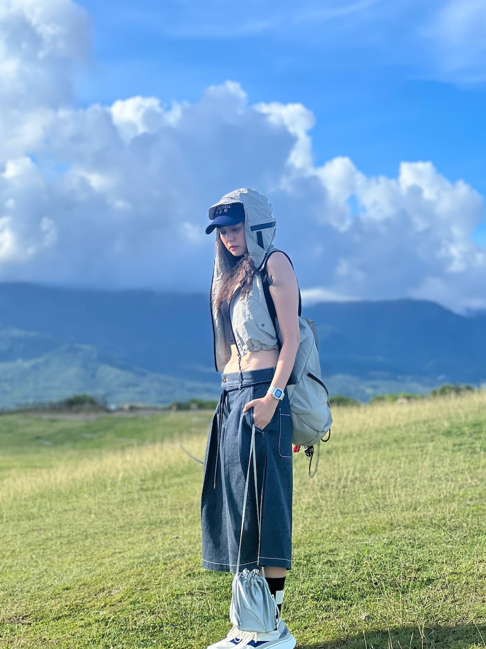 ブルー系のパンツ、ホワイト系のスニーカー、シルバー系のバッグを着用したレディースの夏コーディネートの2枚目の写真