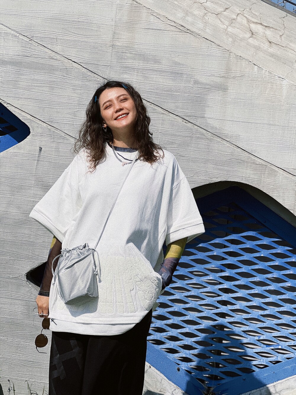 ブラック系のパンツ、ホワイト系のTシャツ/カットソー、シルバー系のバッグを着用したレディースの冬コーディネートの2枚目の写真