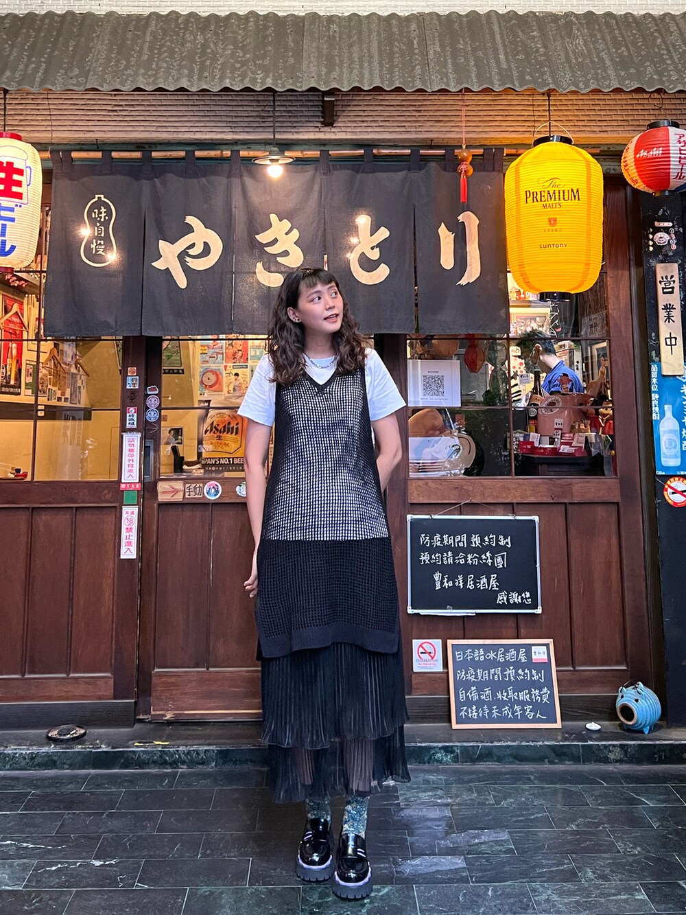 ブラック系のスカート、ブラック系のニット/セーター、ブラック系のローファーを着用したレディースの春コーディネートの2枚目の写真