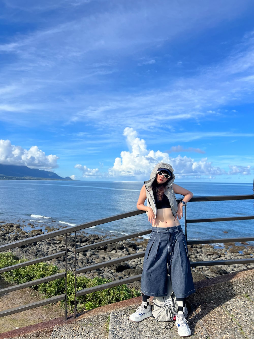 ブルー系のパンツ、ホワイト系のスニーカー、シルバー系のバッグを着用したレディースの夏コーディネートの3枚目の写真