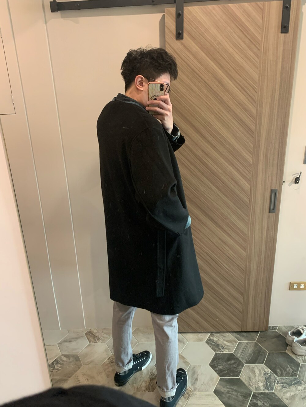 ブラック系のダッフルコート、ブルー系のデニムジャケット、グレー系のチノパンツを着用したメンズの冬コーディネートの2枚目の写真