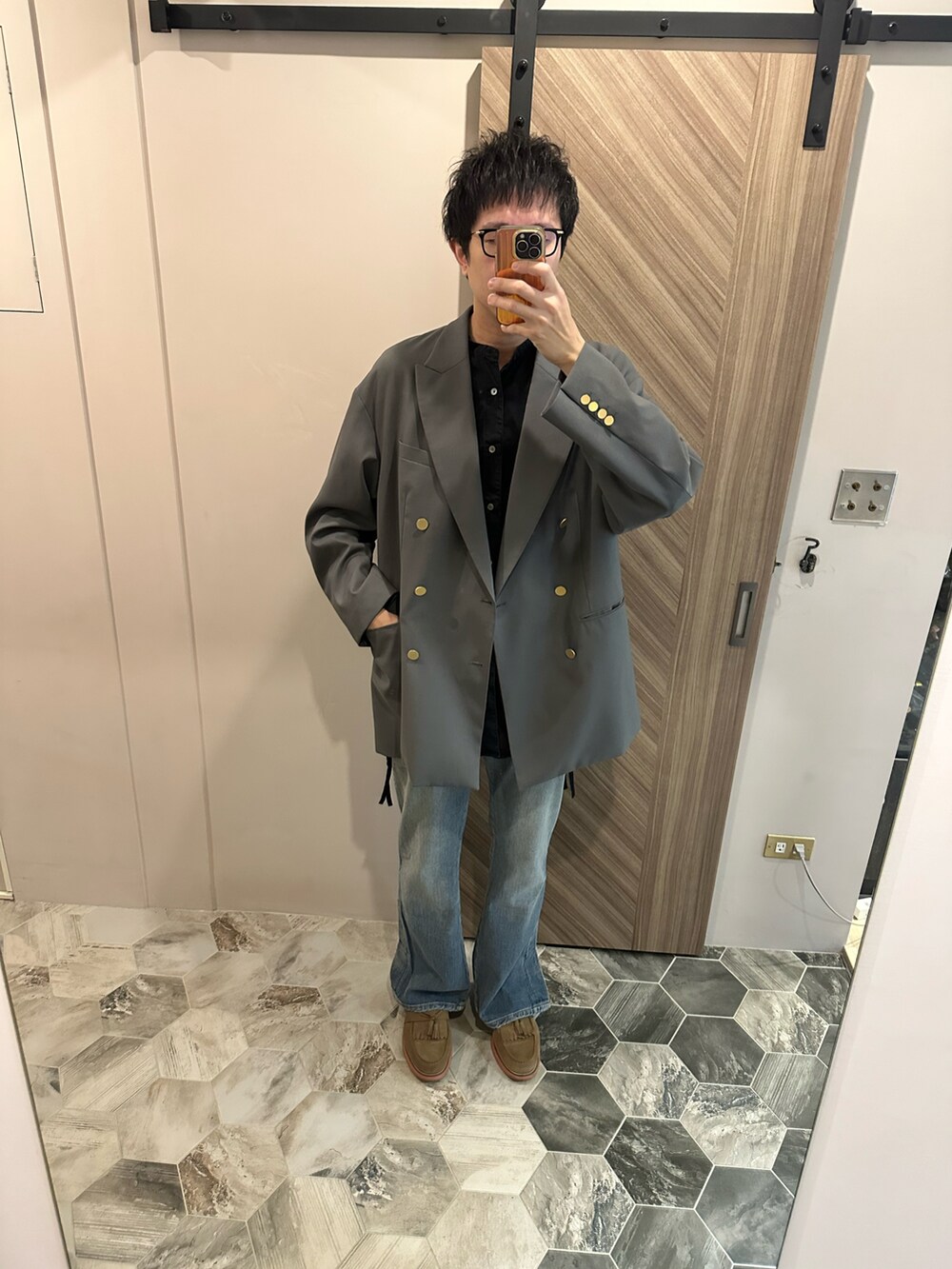 グレー系のテーラードジャケット、ブルー系のデニムパンツ、ベージュ系のローファーを着用したメンズの冬コーディネートの3枚目の写真