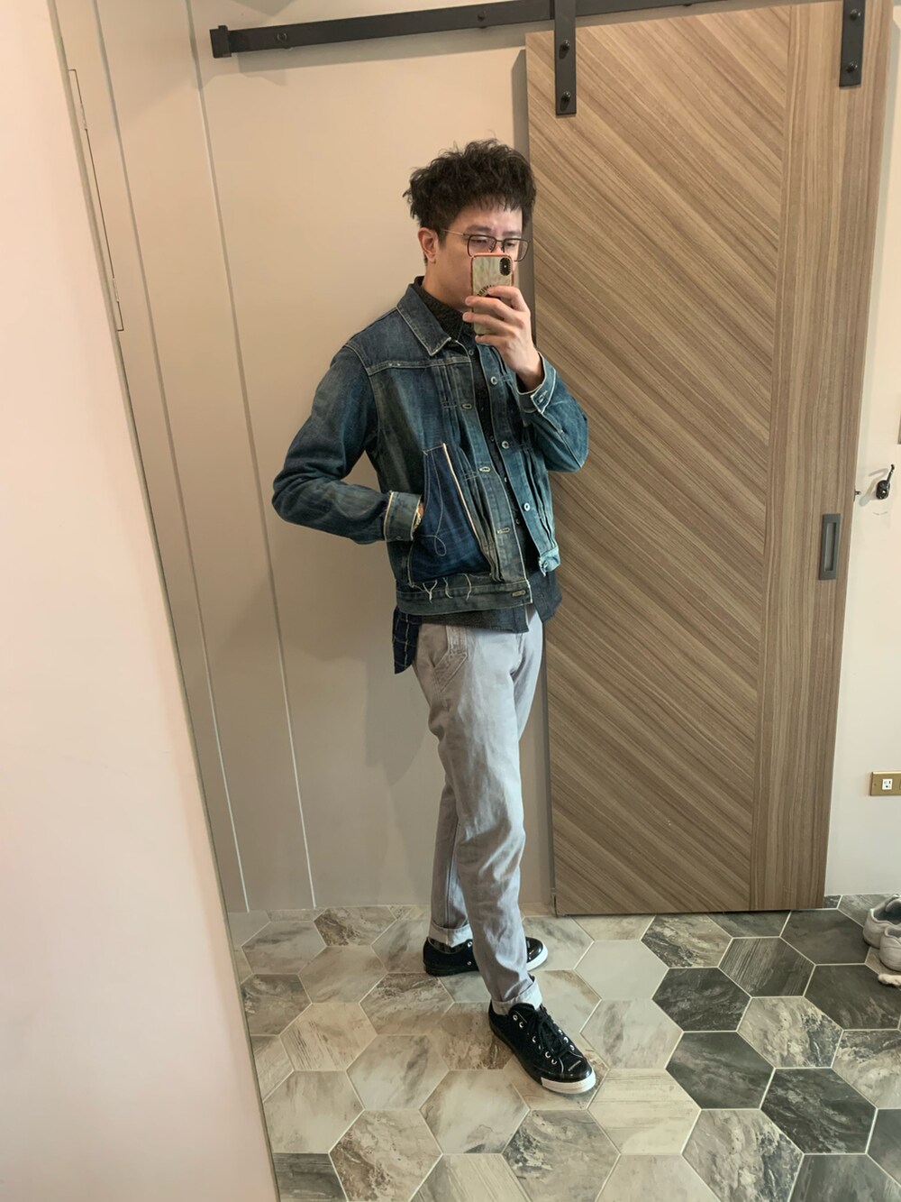 ブラック系のダッフルコート、ブルー系のデニムジャケット、グレー系のチノパンツを着用したメンズの冬コーディネートの4枚目の写真