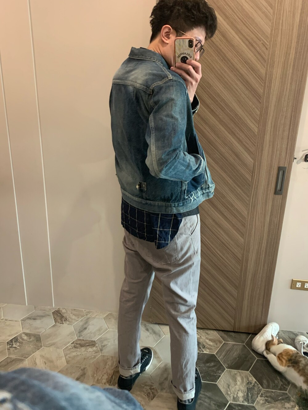 ブラック系のダッフルコート、ブルー系のデニムジャケット、グレー系のチノパンツを着用したメンズの冬コーディネートの5枚目の写真