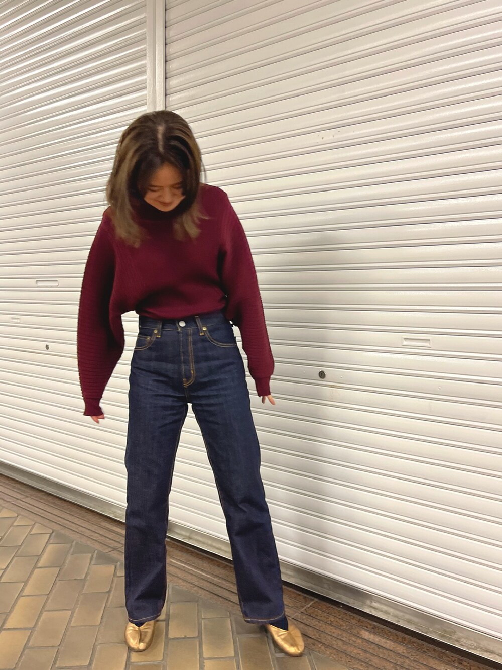 パープル系のニット/セーター、ブルー系のデニムパンツ、その他のバレエシューズを着用したレディースの冬コーディネートの2枚目の写真