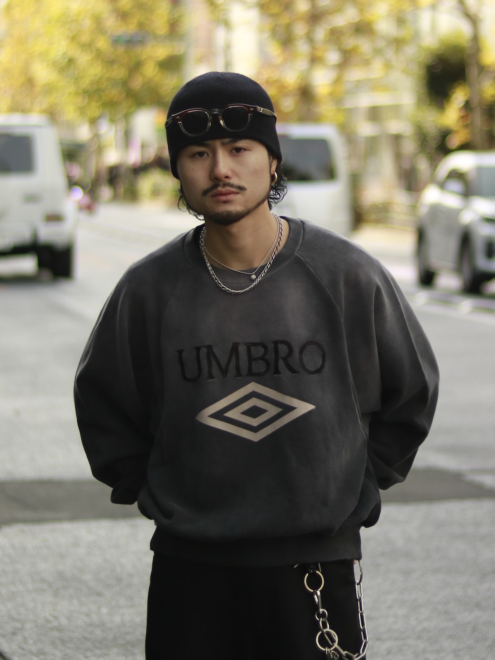 グレー系のスウェット、ブラック系のスラックス、ブラック系のキーホルダーを着用したメンズの冬コーディネートの4枚目の写真