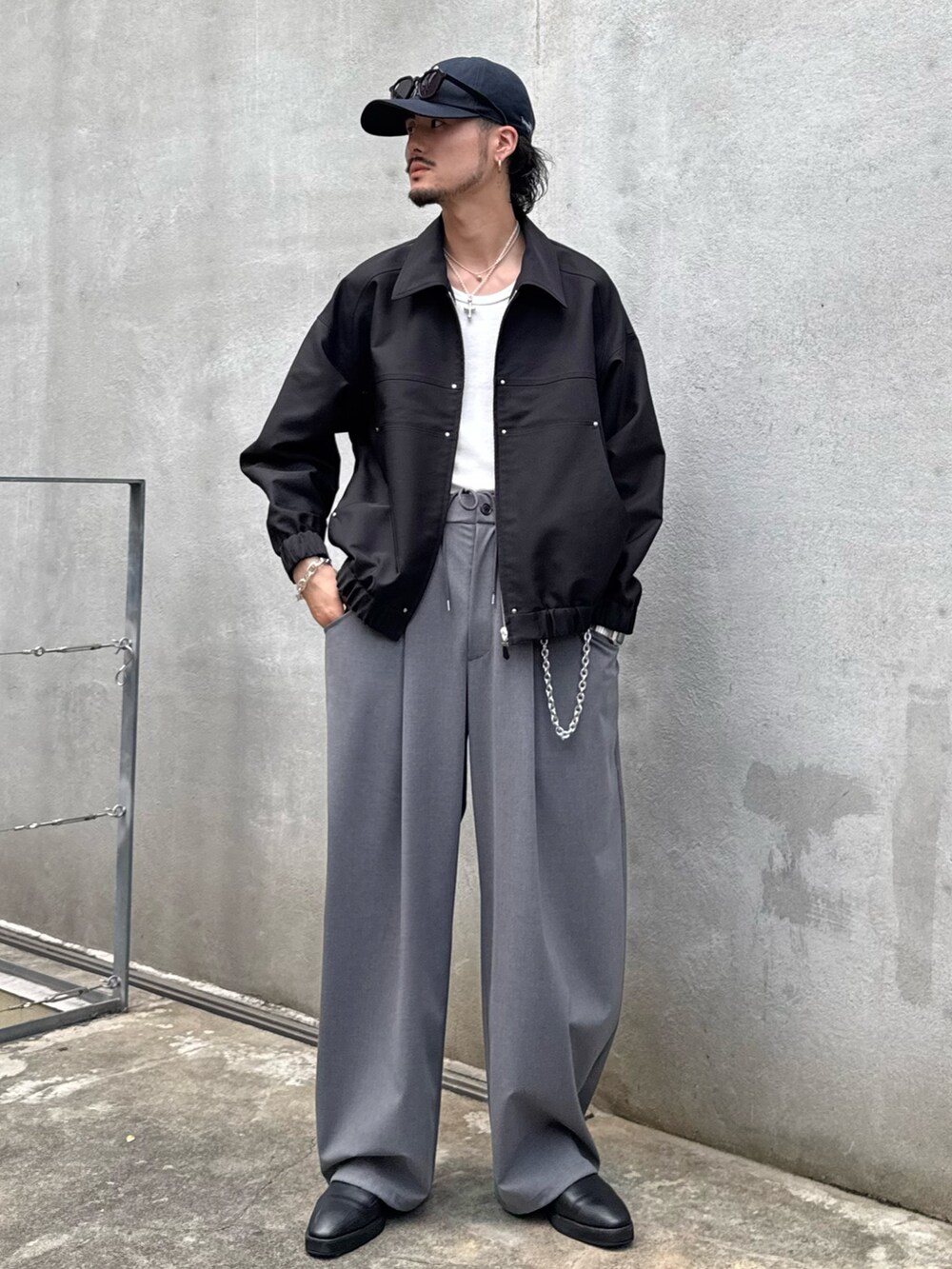 ブラック系のブルゾン、グレー系のスラックスを着用したメンズの秋コーディネートの2枚目の写真