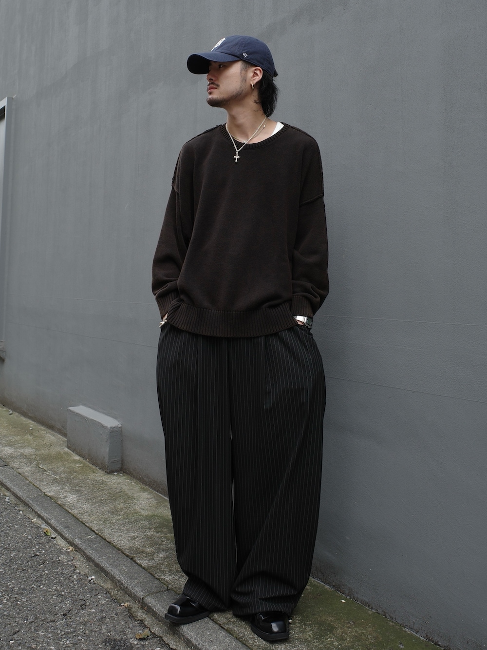 ブラック系のニット/セーター、ブラック系のスラックスを着用したメンズの秋コーディネートの2枚目の写真