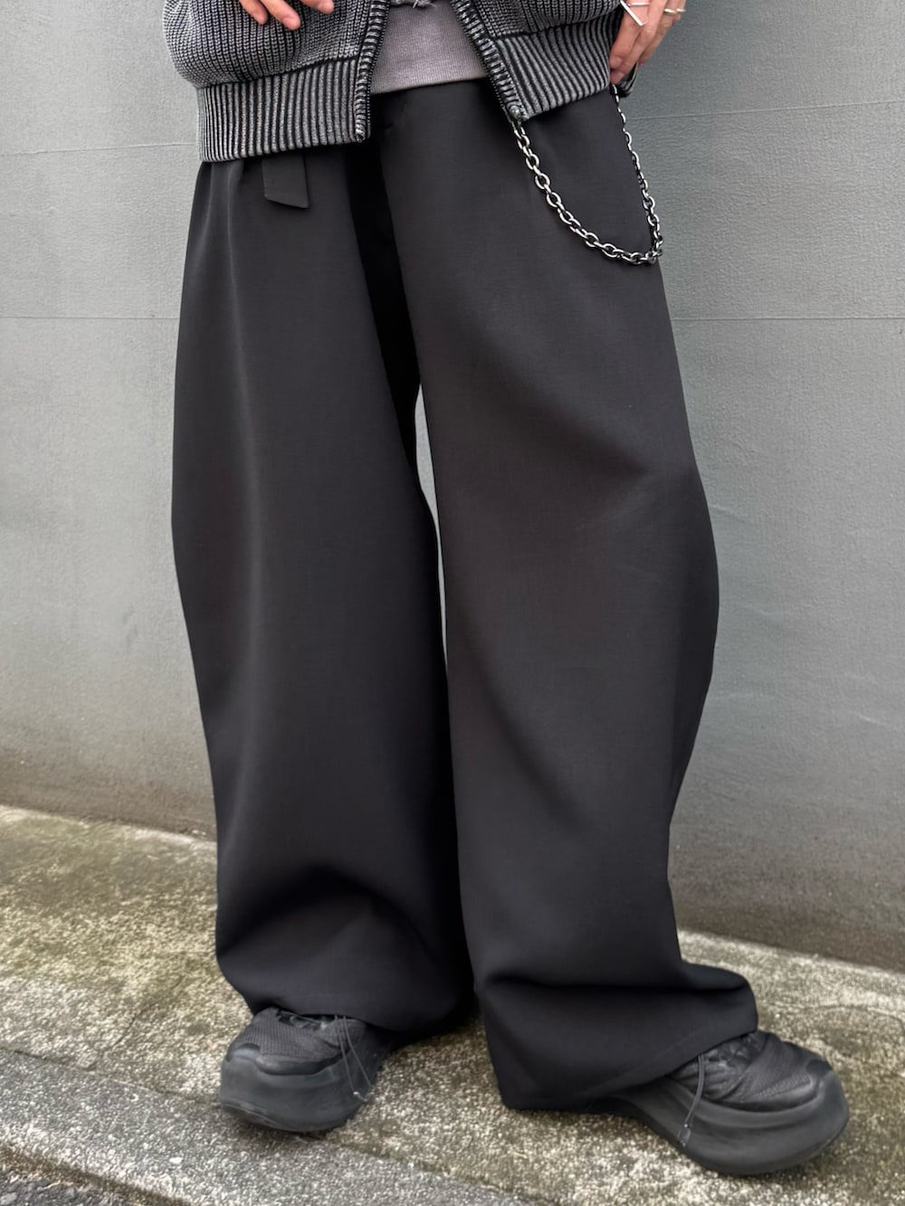 グレー系のパーカー、ブラック系のスラックス、グレー系のスウェットを着用したメンズの春コーディネートの7枚目の写真