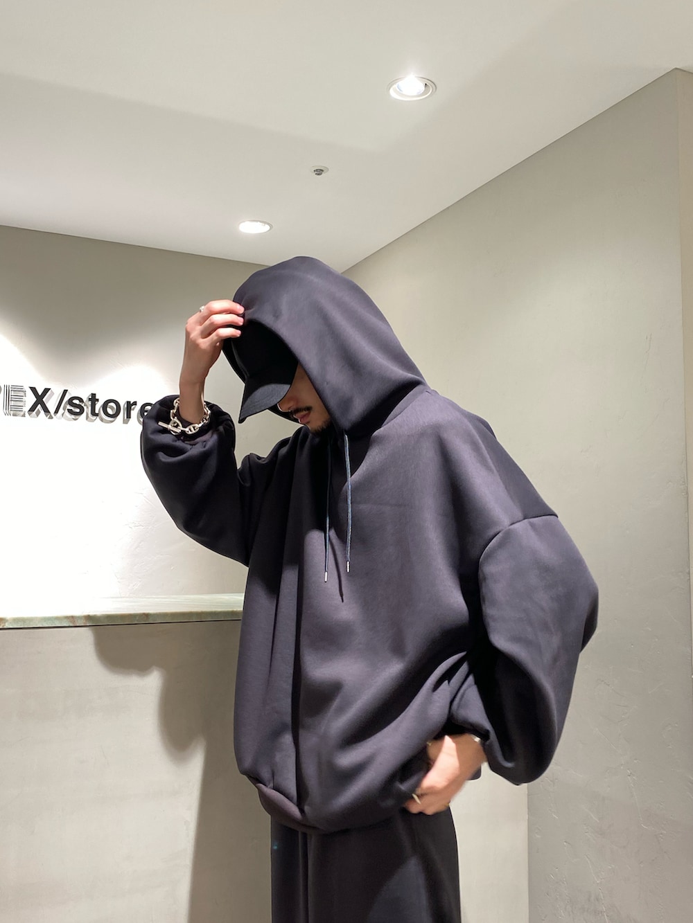 グレー系のパーカー、グレー系のスウェットパンツ、ブラック系のその他シューズを着用したメンズの秋コーディネートの4枚目の写真